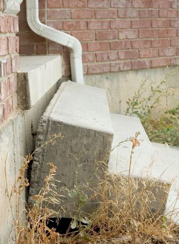 sinking outdoor concrete steps showing cracking and soil washout in Saint Johnsbury