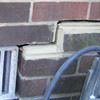 A closeup of a failed tuckpointing job where the brick cracked on a Belmont home.