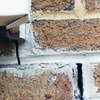 Failed crack repair showing old tuckpointing that cracked on a Laconia home.
