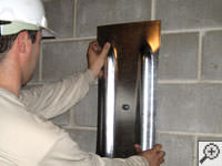 Mounting a foundation wall plate for an earth anchor installation in Brattleboro.
