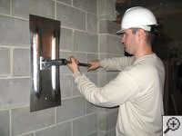 Attempting to straighten a bowed foundation wall by straightening a wall anchor system in a Laconia home.