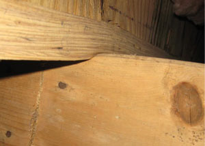 A failing girder showing signs of compression damage in a Vermont and New Hampshire home
