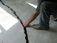 a severely damaged cracked concrete slab floor in Milton