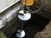 Installing a helical pier system in the earth around a foundation in Colchester
