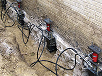Using foundation push piers to lift a foundation during a repair in Bennington.