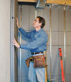 Insulated basement wall panels being placed against a concrete foundation wall in South Burlington
